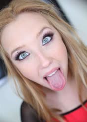 A woman with blonde hair and green eyes sticking out her tongue.