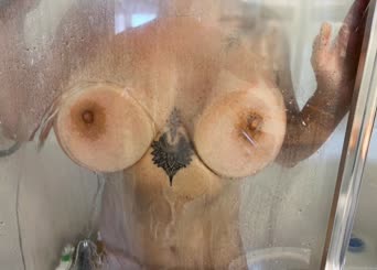 A man washes his breasts in the shower