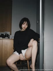 a woman sitting on a chair with her legs crossed . 