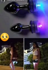  A girl holding a butt horn with blue lights on it.